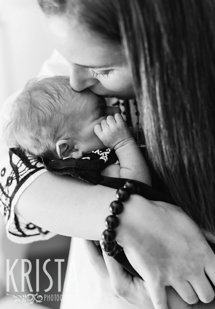 black and white image of mother and newborn baby girl snuggling during lifestyle family newborn baby portrait session