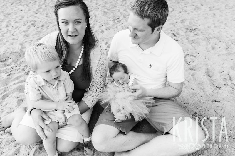 black and white of family in backyard during lifestyle family session with toddler boy and newborn baby girl