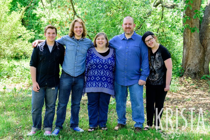 family of five in blue among green trees during springtime mini portrait sessions in New England