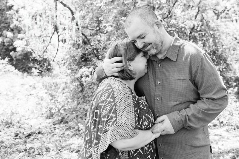 tender moment between husband and wife among trees during springtime mini portrait sessions in New England