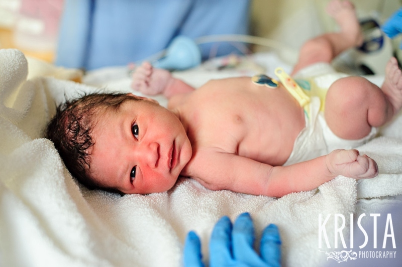 newborn half Asian baby boy in hospital cradle immediately after birth during lifestyle portrait session
