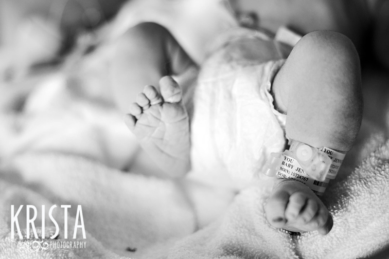 black and white image of newborn baby boy feet immediately after his birth during lifestyle portrait session