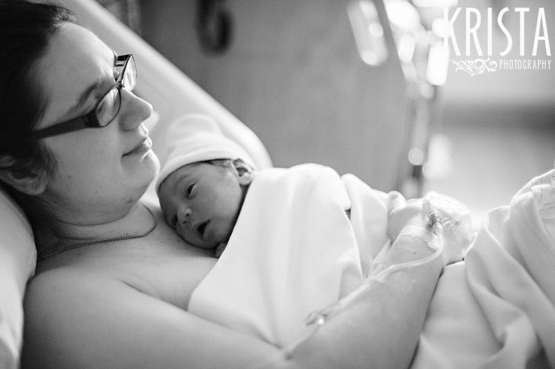 black and white image of new mother and newborn baby boy sharing skin to skin time immediately following baby's birth during lifestyle portrait session in the hospital