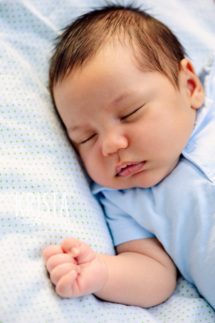 newborn baby boy at one month old during lifestyle portrait session with family outside