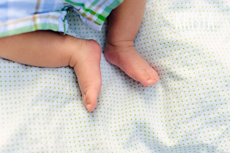 newborn baby boy feet at one month old during lifestyle portrait session with family outside