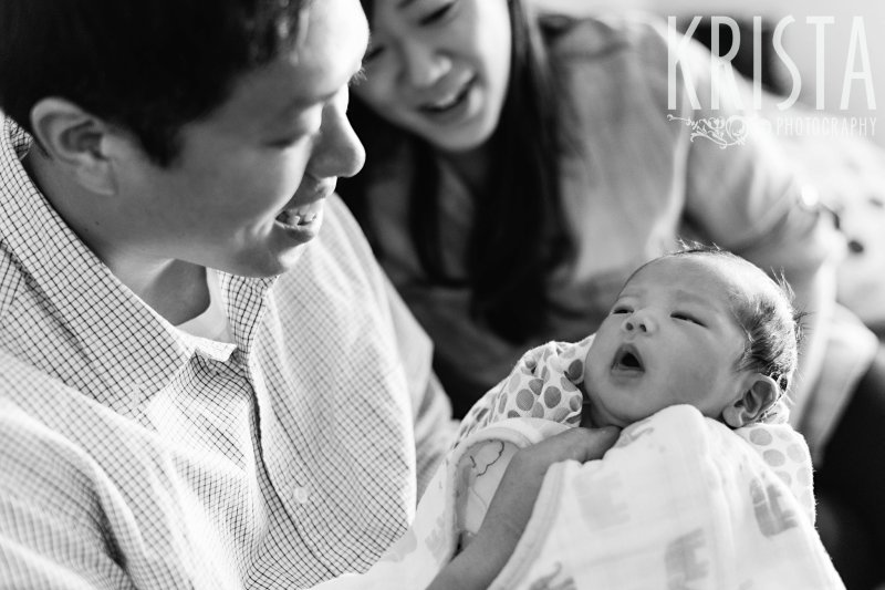 newborn baby boy with his parents in black and white image taken during family portrait session at their home