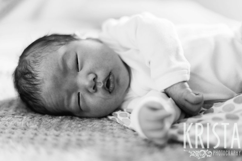 black and white image of newborn baby boy laying on side sleeping