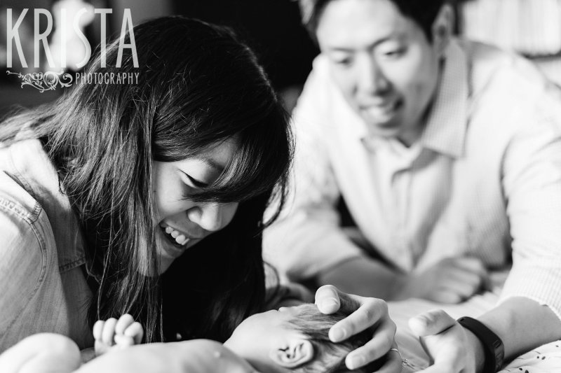 black and white image of parents cooing at newborn baby boy