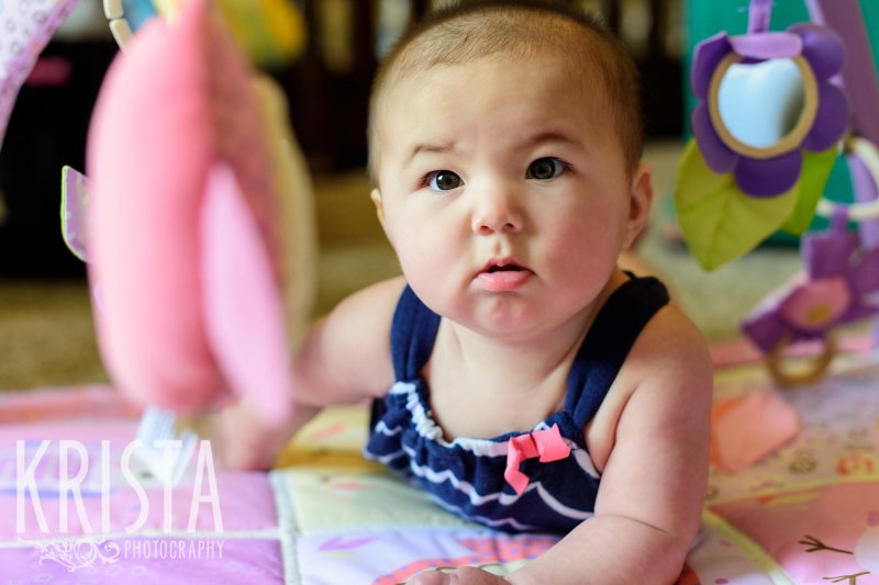 baby girl on her tummy on playmat during lifestyle portrait session at home