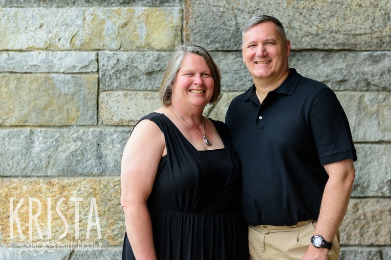 parents beside stone wall during family portrait session in winchester, ma