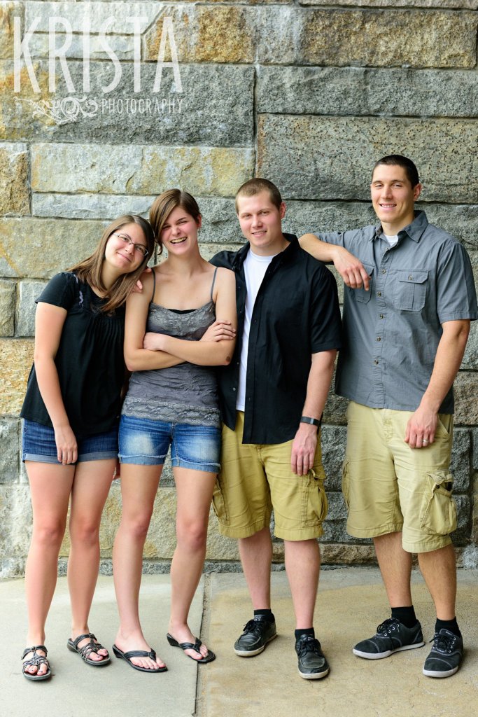 brothers and sisters beside stone wall during family portrait session in winchester, ma