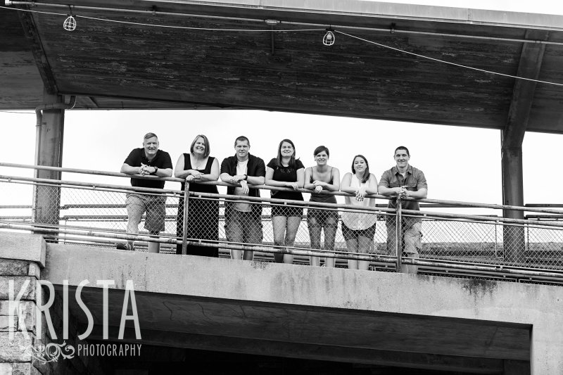 black and white image of parents with four grown children on top of overpass during family portrait session
