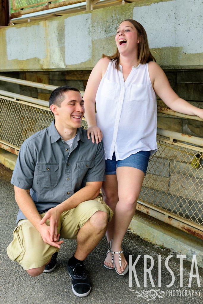 engaged couple laughing on overpass during family portrait session