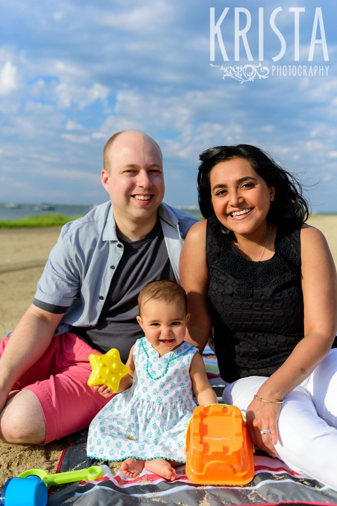 beautiful family on beach of Cape Cod with baby girl in turquoise patterned dress during lifestyle portrait session