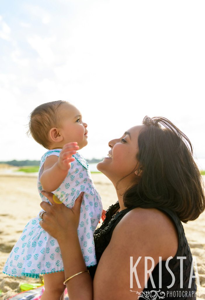 beautiful baby girl on mother's lap on beach of Cape Cod during lifestyle portrait session