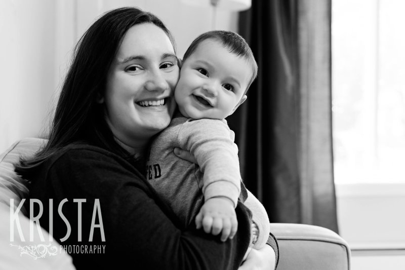 black and white image of six month old baby boy snuggling with mother during lifestyle portrait session at home