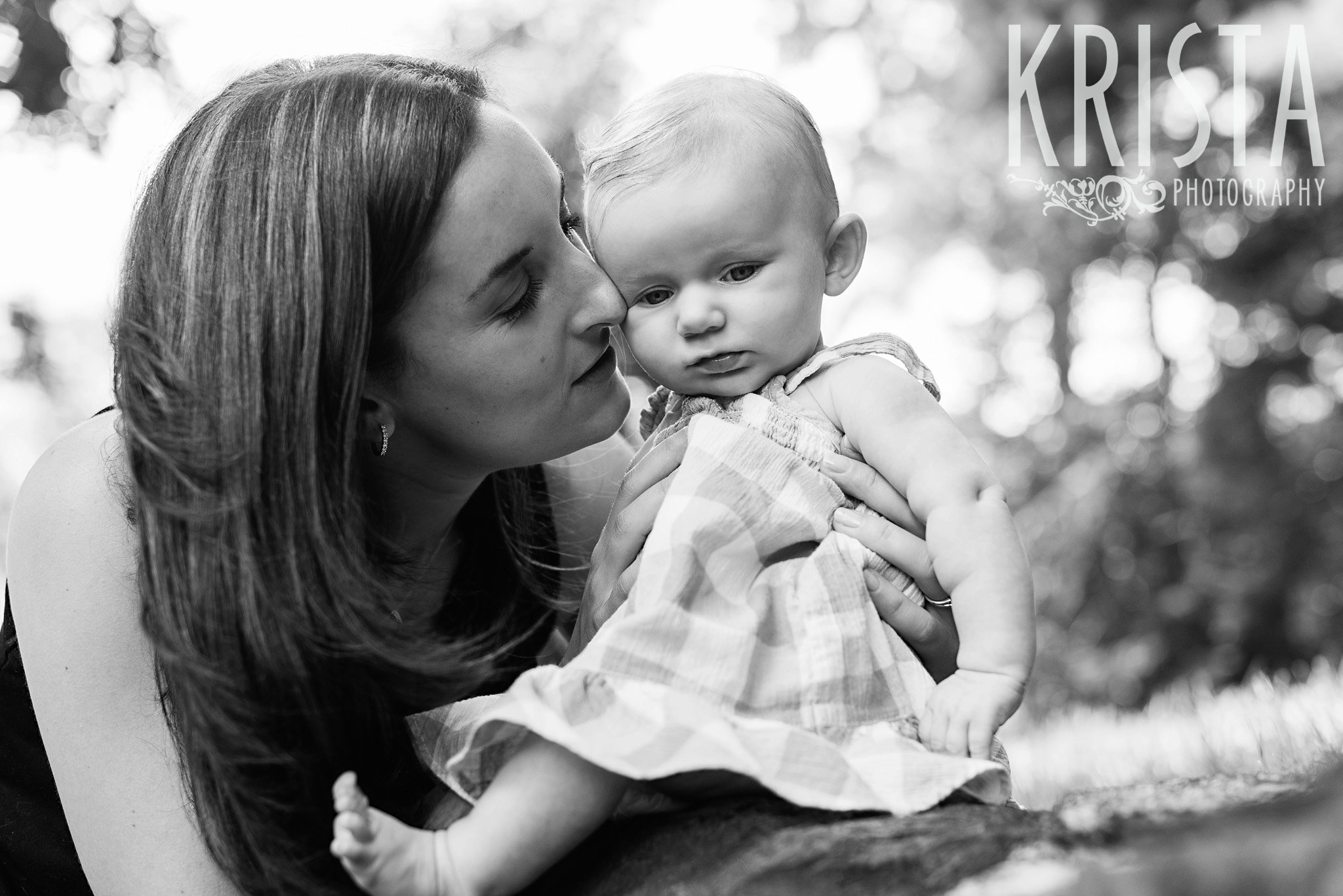 black and white image of mother holding three month old baby girl close with nose on baby's cheek during lifestyle portrait session at family's home