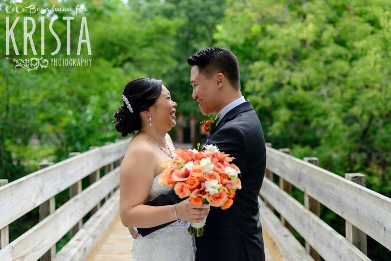 smiling bride and groom on bridge © Krista Photography