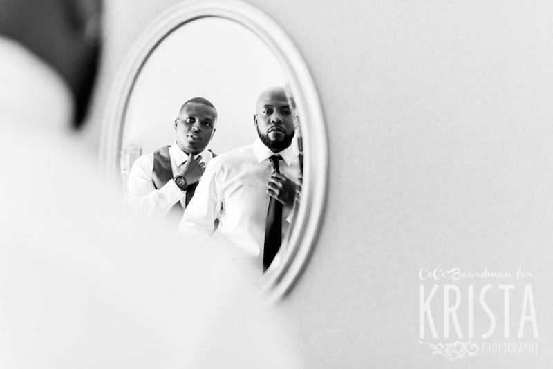 the groom and his groomsmen getting ready in the mirror © Krista Photography - www.kristaphoto.com